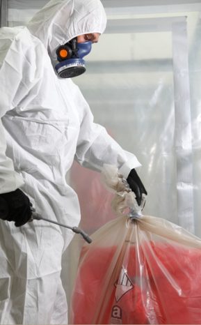 Image shows trained worker in Health and Safety gear disposing of Asbestos.