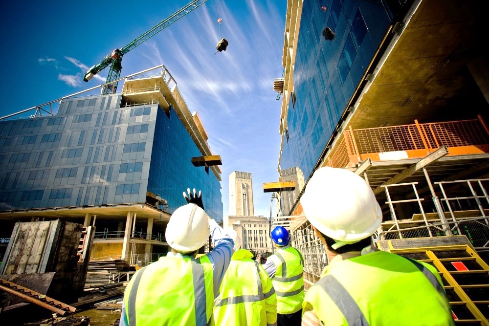 image shows a construction site and a group of builders