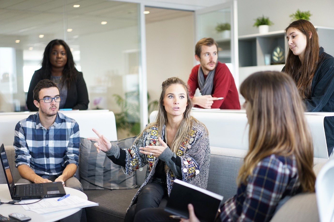 Image shows office workers in discussion.