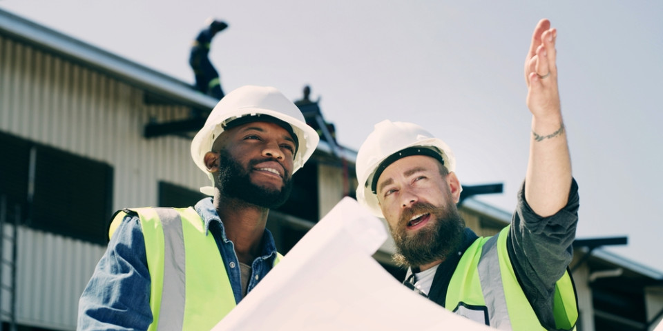 Engineers reviewing a construction site blueprint during site planning and inspection