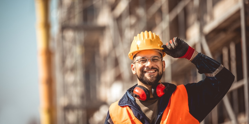 Confident construction worker on a UK construction site representing career progression from entry level to skilled roles and management